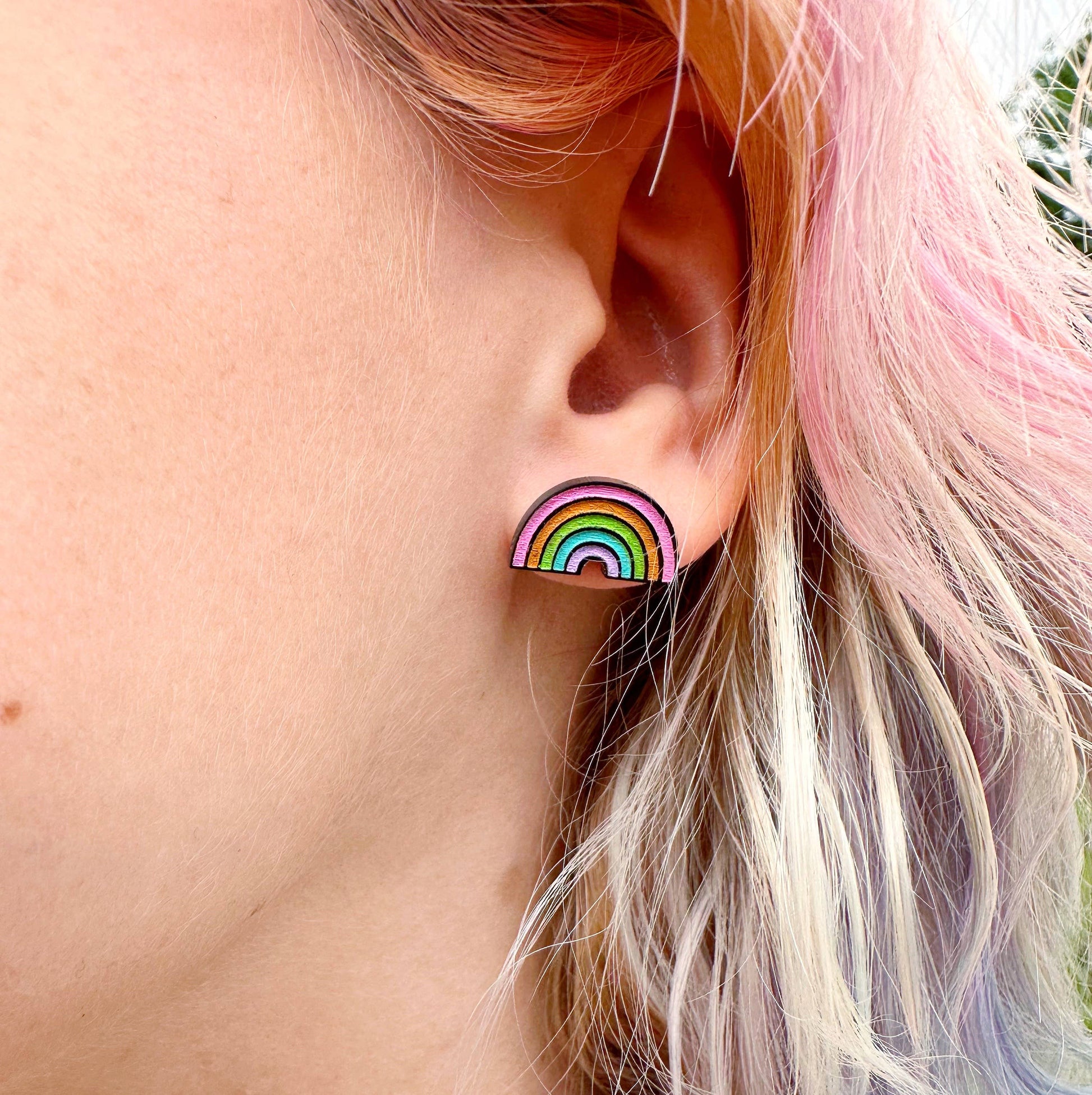 The rainbow earring displayed in an ear 